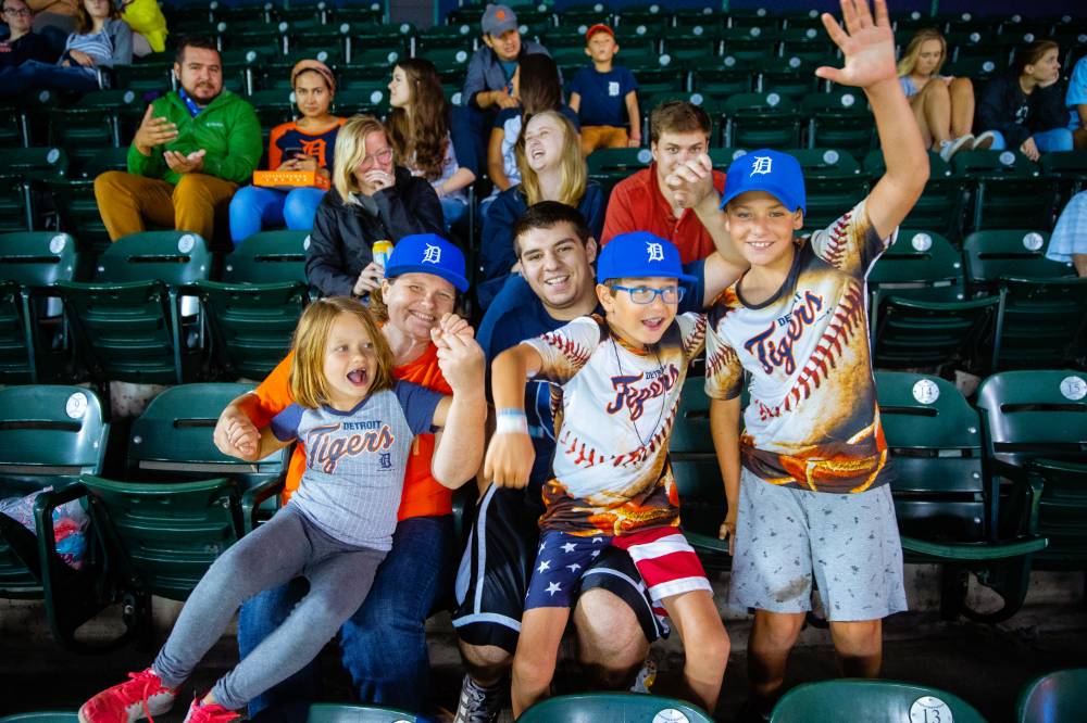 Photo of a family with Detroit Tigers jerseys cheering in the audience